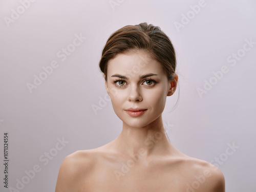 Beautiful young woman posing with hands on hips and looking to the side against a white background