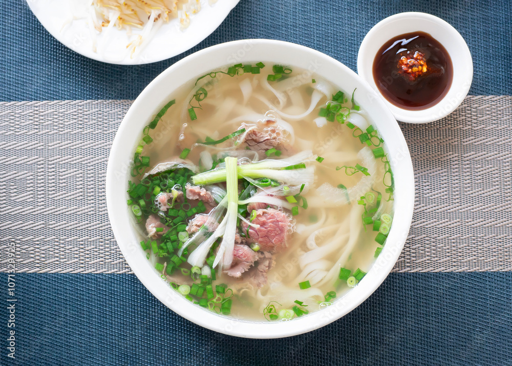 Vietnam traditional pho, Beef noodles. Pho Bo Soup with beef, rice noodles, ginger, lime, chili pepper in bowl. Vietnamese cuisine. Pho Noodle Soup Vietnam traditional pho, Beef noodles. Pho Bo Soup with beef, rice noodles, ginger, lime, chili pepper in bowl. Vietnamese cuisine. Pho Noodle Soup