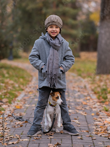 Caucasian boy walking with dog jack russell terrier in autumn park. photo