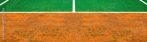 A tennis court featuring a vibrant green surface on one half and a clay-like orange texture on the other, ready for a match. photo