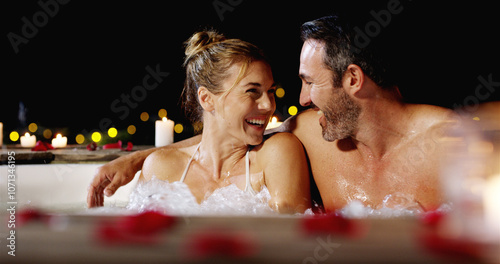 Happy couple, night and jacuzzi with date for honeymoon vacation or luxury holiday together at resort. Man, woman or lovers enjoying water with hot tub in late evening for love, romance or getaway photo