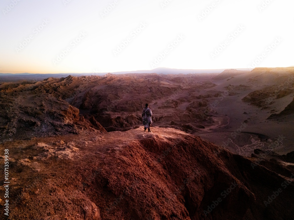Young man watching the scenery of San Pedro de Atacama desert at sunset in northeastern Chile Young man watching the scenery of San Pedro de Atacama desert at sunset in northeastern Chile