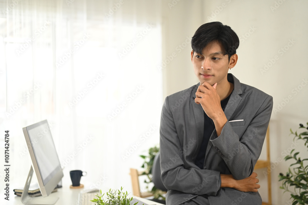 Focused businessman in suit thinking and analyzing work tasks in his office Focused businessman in suit thinking and analyzing work tasks in his office