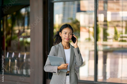 Mixed businesswoman in casual suit and talking with phone before to go to meeting face to face with customers. photo