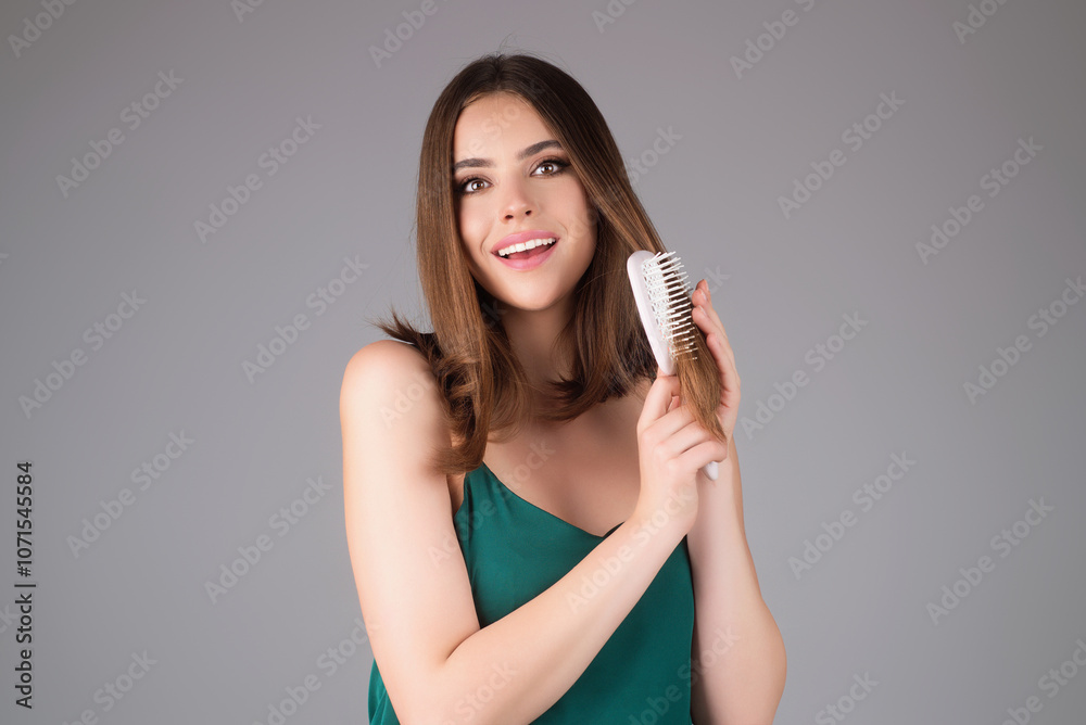 Fototapeta premium Beautiful woman combing her hair in studio.