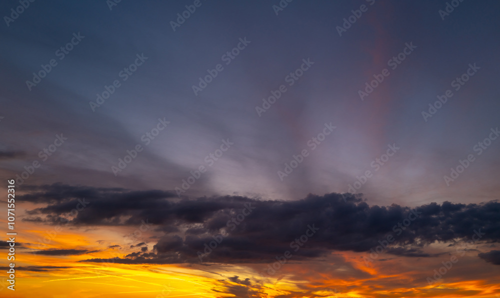 Fototapeta premium Sunrise sky background. Dramatic scenery sunset. Sky with clouds in Sunrise sky light background. Sunrise with clouds in various shapes. Calm Sunrise sky and sun through clouds over.