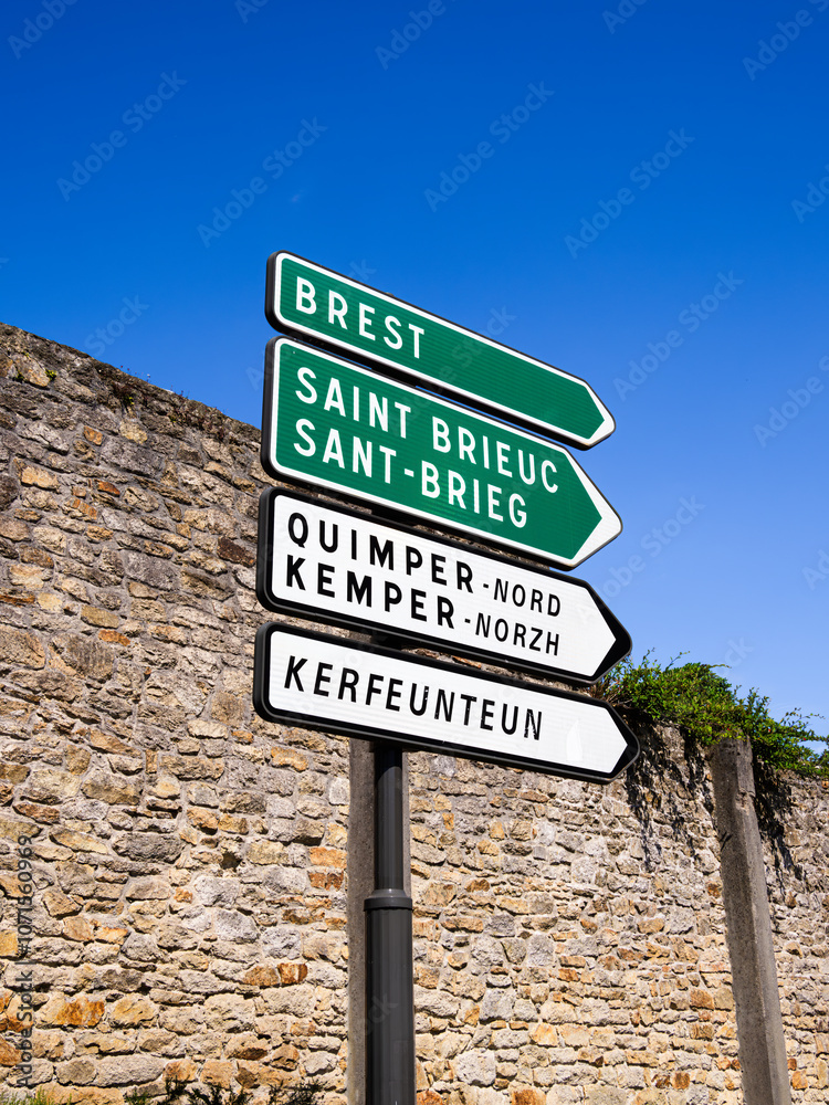 A directional signpost with multiple arrows indicating various destinations in Brittany, France. A directional signpost with multiple arrows indicating various destinations in Brittany, France.