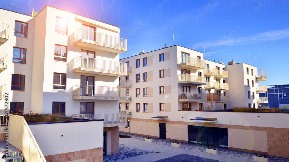 Modern apartment buildings on a sunny day with a blue sky. Facade of a modern apartment building. Contemporary residential building exterior in the daylight. Modern apartment buildings on a sunny day with a blue sky. Facade of a modern apartment building. Contemporary residential building exterior in the daylight.