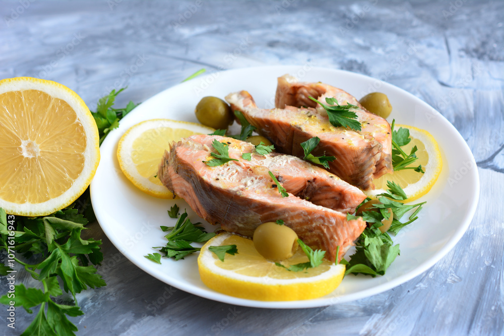 a plate of salmon with lemons and olives on it  