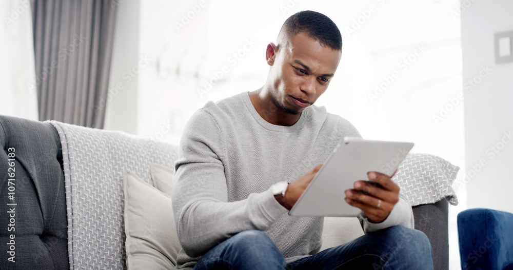 Man, tablet and relax on sofa with ebook, streaming service and ecommerce in home. Male person, scroll and tech in living room for social media app, online shopping or connectivity for game download