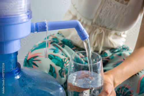 Pouring Water from Demijohn into Glass photo