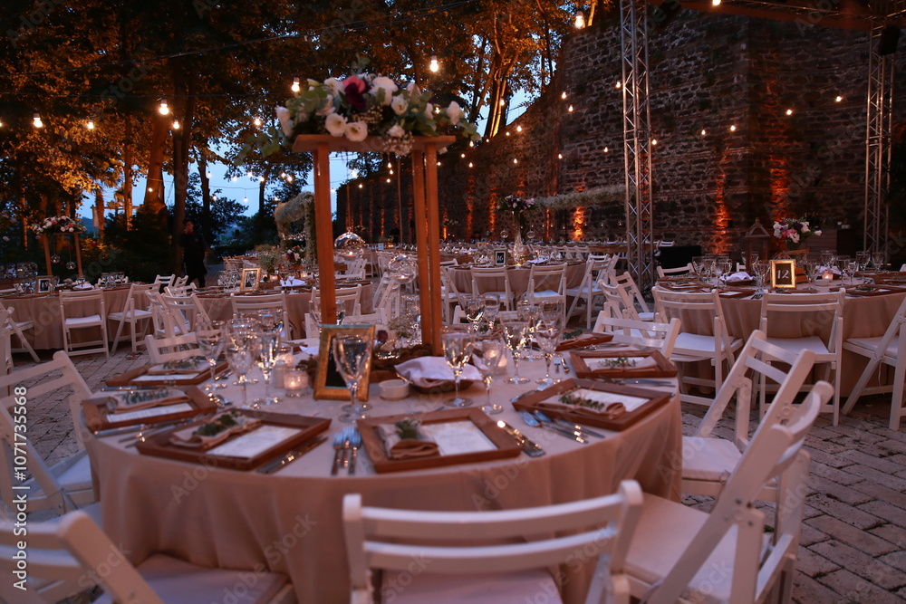 Romantic seaside wedding reception with twinkling lights and white floral centerpieces