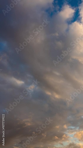 Dramatic clouds time lapse vertical video. Motion of the clouds at sunset or sunrise.