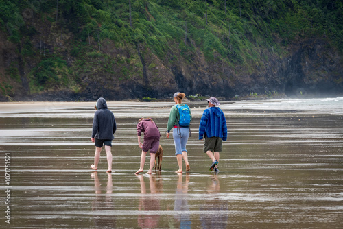 Family of four with a dog Strolling on the Shore at Cape Lookout State Park, Oregon