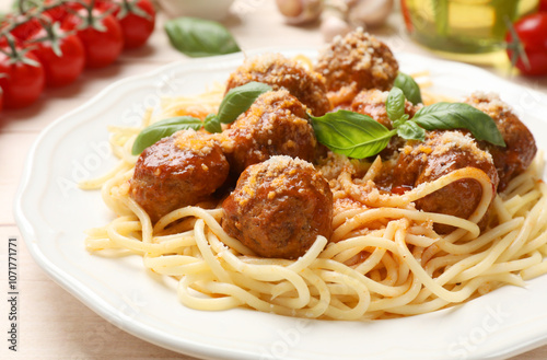 Delicious pasta with meatballs and ingredients on light wooden table, closeup