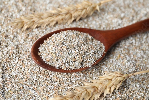 Spoon with fresh rye bran and spikelets, closeup