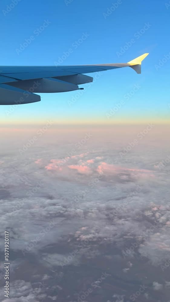 Aerial view of clouds illuminated by sunset as seen from an airplane window Aerial view of clouds illuminated by sunset as seen from an airplane window