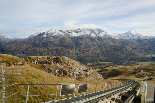Swiss railway in the Alps of Graubünden in autumn with yellow-colored trees.