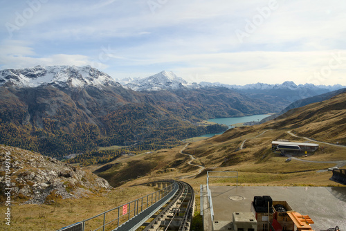 Swiss railway in the Alps of Graubünden in autumn with yellow-colored trees.
