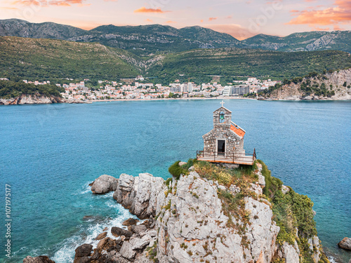 Aerial photography of Petrovac's coastline in Montenegro, highlighting the scenic beauty of its cliffs, islets, and historic Sveta Nedjelja church, a popular destination for travelers. photo