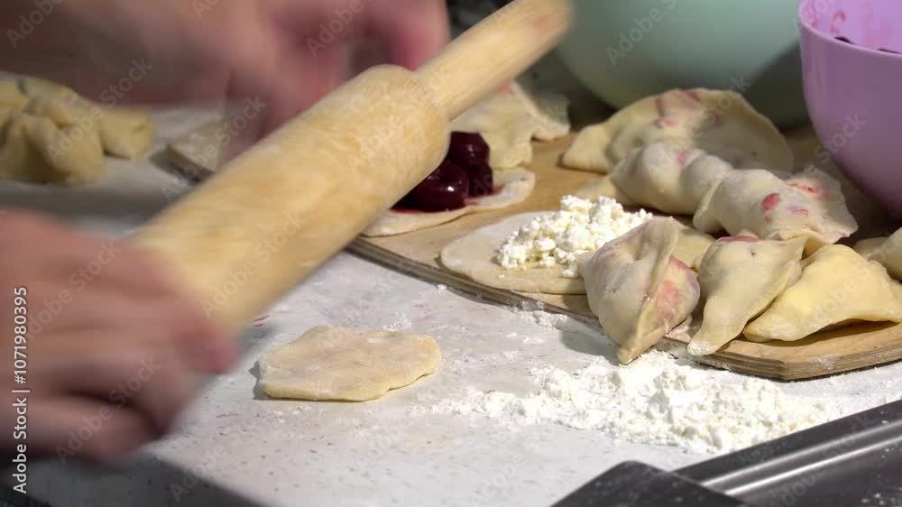 cooking national food, making dumplings from dough, women's hands, rolling pin, sugar, cottage cheese, cherries in dumpling filling
cooking national food, making dumplings from dough, women's hands, rolling pin, sugar, cottage cheese, cherries in dumpling filling