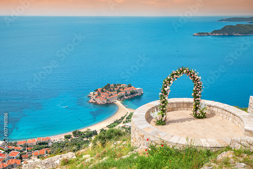 Obraz na płótnie A romantic wedding ceremony at Montenegro Sveti Stefan viewpoint, with an arch adorned in flowers overlooking the Adriatic Sea. w salonie