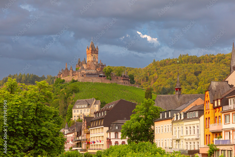 Obraz premium Picturesque view of Cochem and Reichsburg castle under cloudy sky on Moselle river, Germany