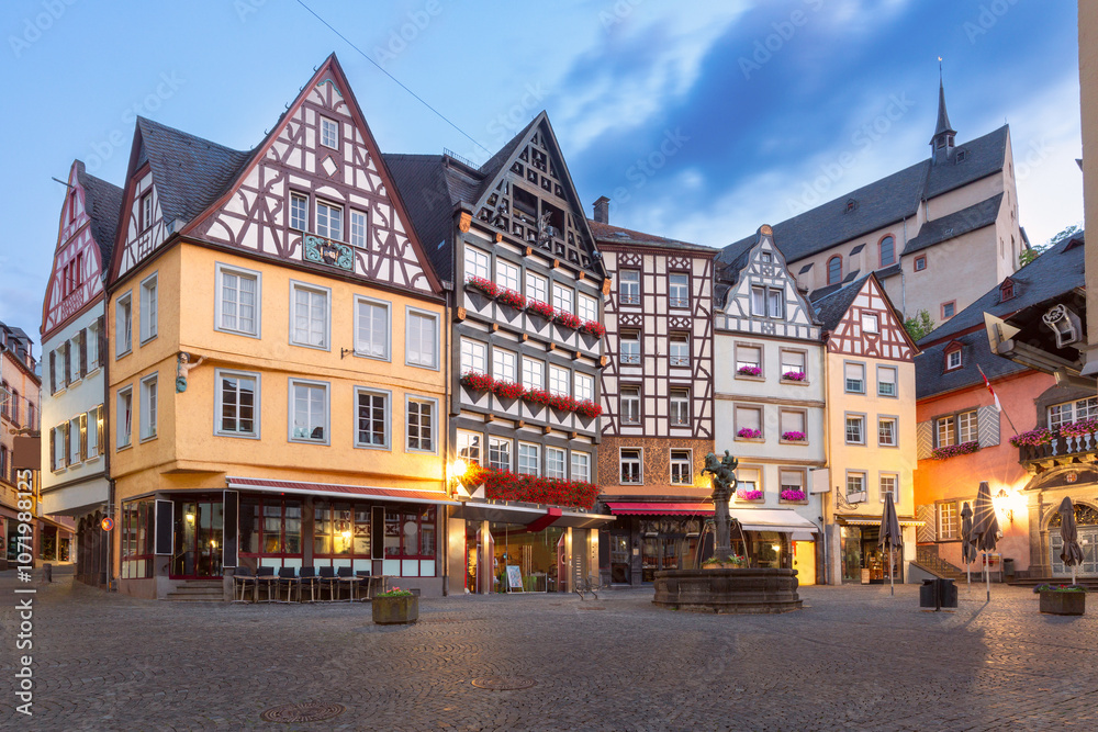 Morning view of the historic market square in Cochem with traditional half-timbered houses decorated with flowers, Germany Morning view of the historic market square in Cochem with traditional half-timbered houses decorated with flowers, Germany
