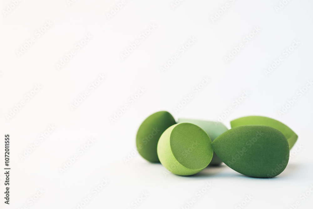 Green makeup sponges on a white background. A minimalist composition showcasing beauty tools for foundation blending, perfect for skincare and cosmetics themes Green makeup sponges on a white background. A minimalist composition showcasing beauty tools for foundation blending, perfect for skincare and cosmetics themes