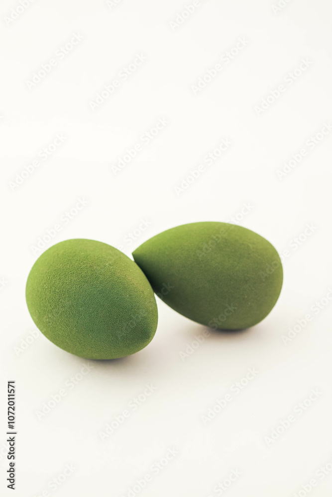 Green makeup sponges on a white background. A minimalist composition showcasing beauty tools for foundation blending, perfect for skincare and cosmetics themes Green makeup sponges on a white background. A minimalist composition showcasing beauty tools for foundation blending, perfect for skincare and cosmetics themes