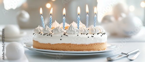 A classic birthday cake adorned with white frosting and lit candles, ready for celebration in a festive, softly lit setting. photo