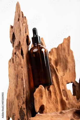 Amber Glass Dropper Bottle with Rustic Wood for Organic Skincare and Aromatherapy Display photo