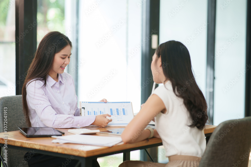 Businessman, two Asian women give advice, discuss work, documents on laptop at office Businessman, two Asian women give advice, discuss work, documents on laptop at office