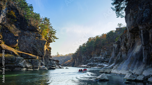 Autumn scenery of the Hantan River Columnar Joint Road, with canyons and cliffs formed by the river flowing through the volcanic terrain. (emerald water, blue sky and colorful leaves)