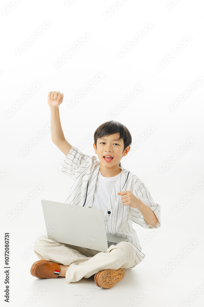 Happy Asian little boy sitting typing laptop while hands up raised arms isolated on white background, online learning concept, Looking at camera and full body composition. Happy Asian little boy sitting typing laptop while hands up raised arms isolated on white background, online learning concept, Looking at camera and full body composition.