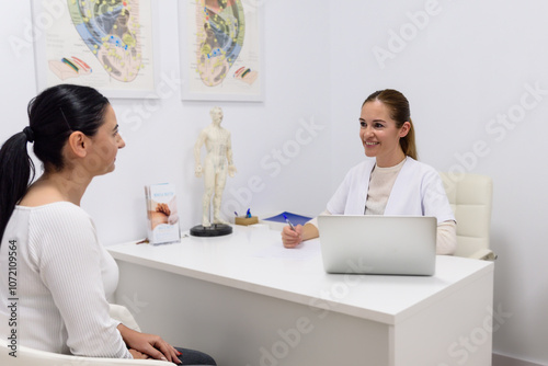 Doctor explaining acupuncture treatment to patient in clinic