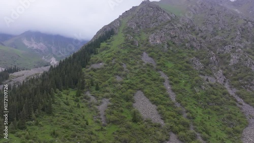 Ala Archa National Park at summer day in Kyrgyzstan, aerial view with truck to the left camera movement. photo