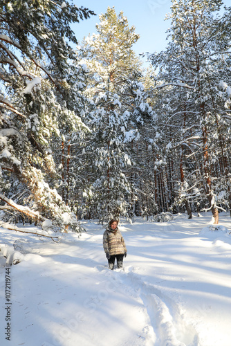 In a snowy winter forest, on Christmas Day, a woman stands knee-deep in snowdrifts