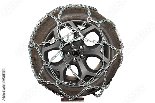 Obraz na płótnie A rugged tire wrapped in chains resting on a stand in a workshop for winter preparation, isolated on white background. w salonie