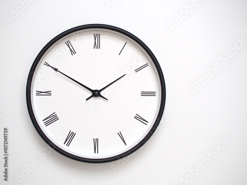 Clock Showing 13.50/01.50 with Roman Numerals – Simple Round Clock for Concepts of Time Management and Scheduling. photo