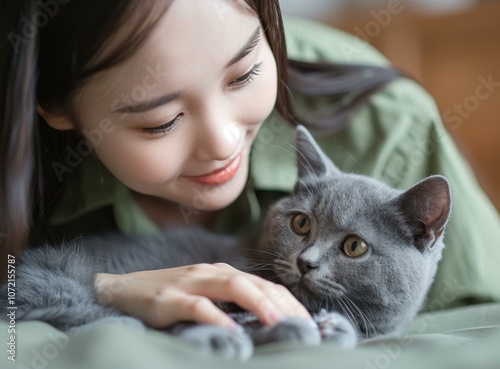 A young woman is petting a gray cat photo