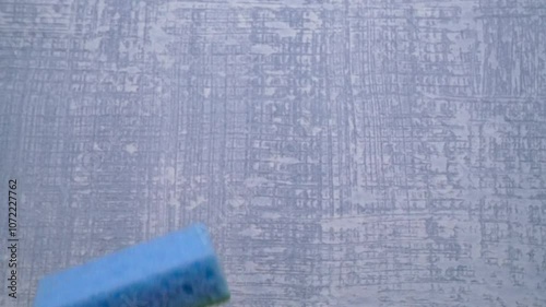 A Blue Sponge Sitting on a Textured Background, Reminding Us of Cleanliness and Hygiene
