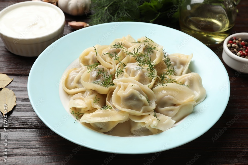 Delicious pelmeni with dill served on wooden table, closeup Delicious pelmeni with dill served on wooden table, closeup