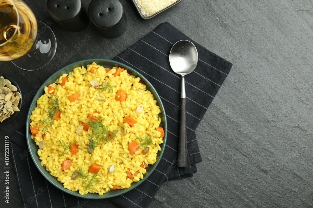 Delicious pumpkin risotto served on black table, flat lay. Space for text Delicious pumpkin risotto served on black table, flat lay. Space for text