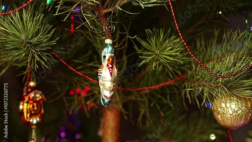 Parrot. Man hanging Christmas tree decorations. Мan's hands. Christmas tree toy decorations. New Year and Merry Christmas. Live christmas tree with garlands and toys