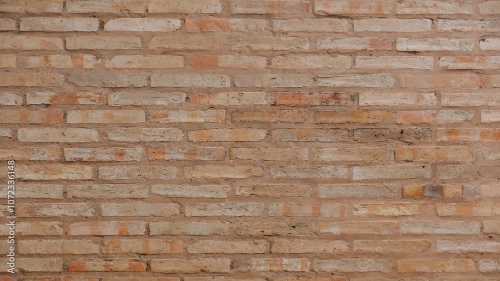 Obraz premium Old weathered sand colored brick wall background for stock photo