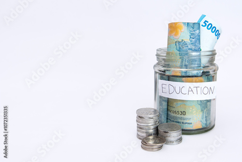 some bills rupiah in a clear jar for education