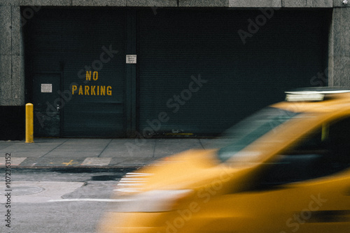 A vibrant yellow taxi is speeding past a prominently displayed no parking sign