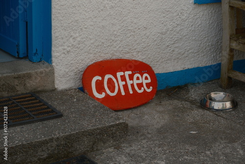 Red coffee sign outside rustic cafe 