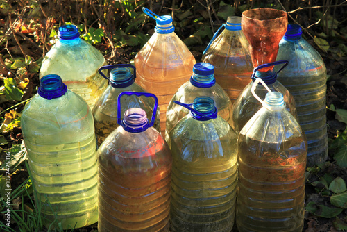 Water, supply and storage. Plastic bottles with water. Accumulation of rainwater. Reservoirs filled with rainwater. Water for irrigation. Summer house and garden plot. Drought and watering the fields photo